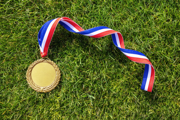 金牌在草地上用空白的脸为文字，概念为胜利或成功图片下载