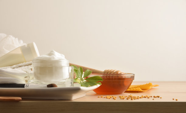 木桌上放着含有蜂蜜提取物的化妆品、乳霜和洗液图片下载