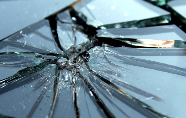 带着小碎片的碎玻璃躺在黑色的表面上图片下载