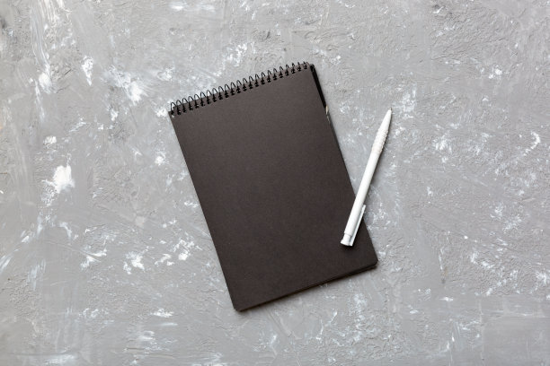 学校笔记本在彩色背景，螺旋黑色记事本在一个表顶视图图片下载