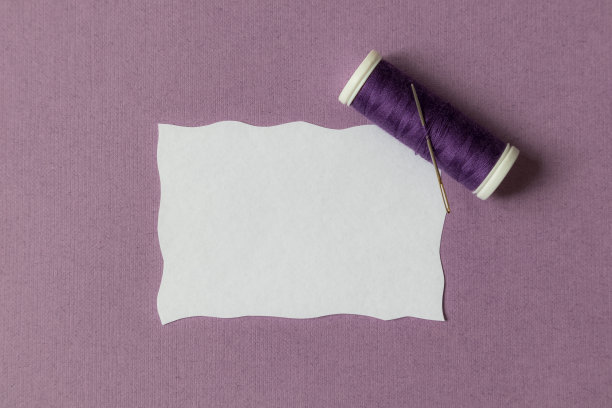 一卷紫色的线和一根针，还有一个放文字的地方。工作室。图片下载