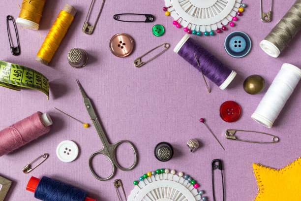 带缝纫工具的框架。缝纫线，针，别针，剪刀，纽扣在紫色的背景上有一个地方的文字。前视图,图片下载