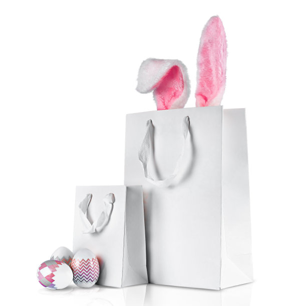 照片孤立在白色背景上。网上购物的概念为复活节，采购和销售的假期。带兔子耳朵的礼物袋图片下载