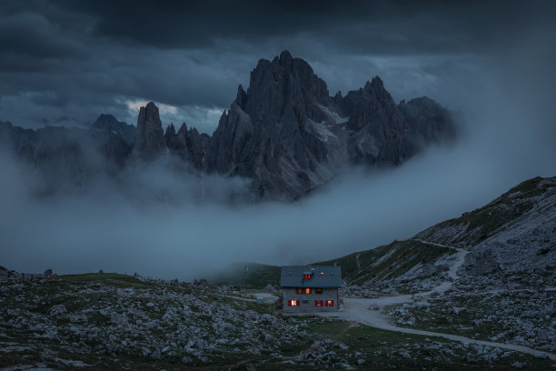 Rifugio Lavaredo山间小屋，在意大利的白云石阿尔卑斯山脉前徒步旅行，夜间从三峰俯瞰，雾气弥漫图片下载