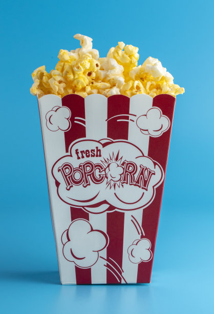 爆米花在红色和白色条纹容器在蓝色背景图片下载