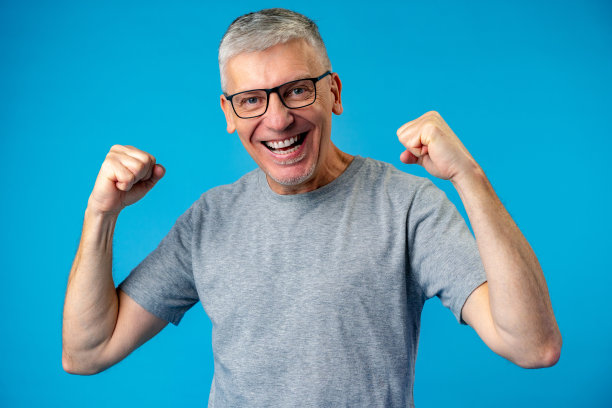 中年男子在蓝色的背景上庆祝成功图片下载