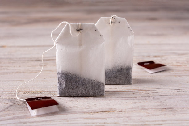 白色的木桌上放着茶包图片下载