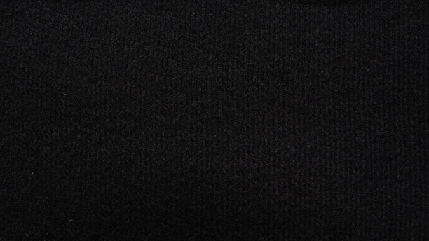 黑色法兰绒铺设在地板上的顶视图是一个美丽的毛毡织物背景，是完美的设计，用于文字和其他设计。黑色法兰绒背景图像的纹理图片下载