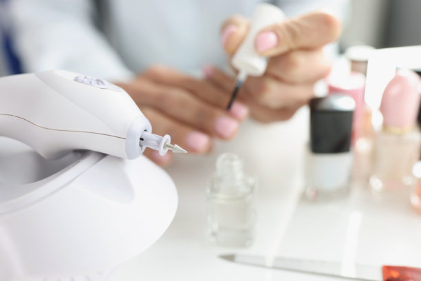 在现代美容院，美甲师妇女手磨装饰指甲剪图片下载