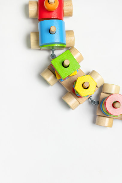 白色背景上的彩色方块木制火车。用天然木材制成的五颜六色的儿童玩具。环保玩具，游戏，不含塑料。婴幼儿玩具。平铺俯视图图片下载