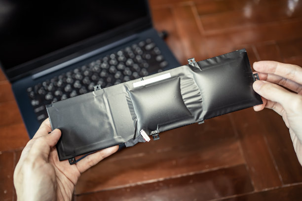 手里拿着肿胀的笔记本电池图片下载