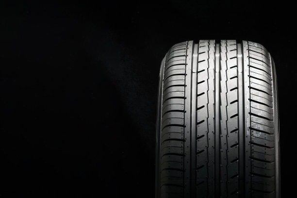 新的经济环保夏季轮胎在黑色背景，copyspace广告空间。图片下载