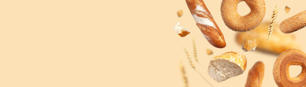 创新食品的概念。各种各样的面包，米色背景上飞舞的麦穗。经典的小麦圆面包，法棍面包，小圆面包，芝麻百吉饼。为面包房做广告的有机健康新鲜面包图片下载