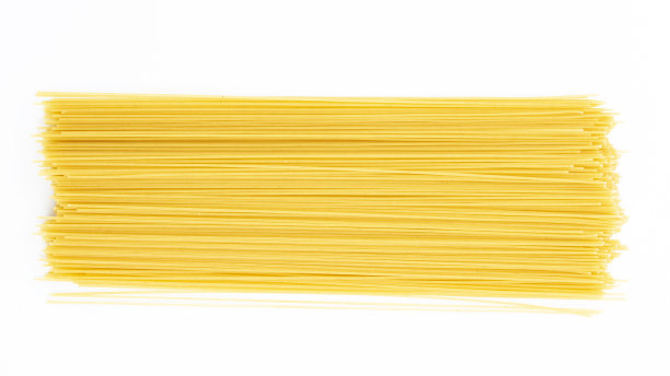 一堆生的长意大利面孤立在白色的背景上。图片下载