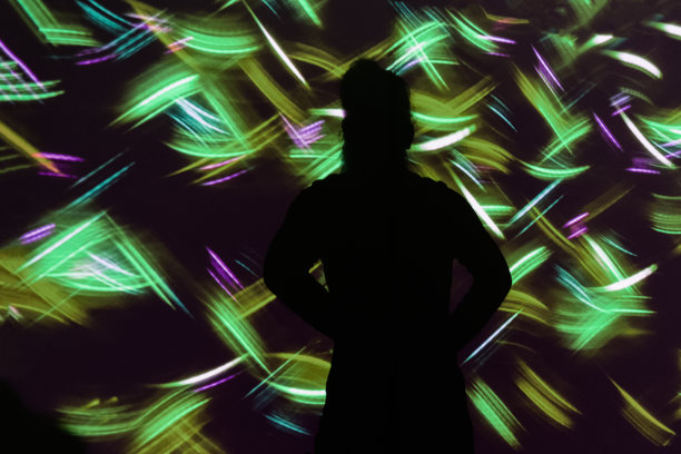 年轻女子看着未来抽象多彩的光模式图片下载