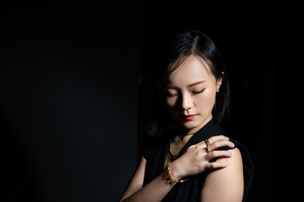 美丽的亚洲女人的肖像穿着一套豪华的珠宝金项链，戒指和耳环图片下载