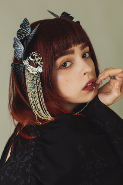 哥特式红发女孩，穿着黑色礼服，戴着珠宝。美写作者。时尚的时尚服装。嘴唇穿刺。手上戴着戒指的哥特式模型。红色的头发图片下载