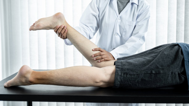 女理疗师通过拉伸治疗病人受伤的腿部和脚踝进行康复治疗图片下载