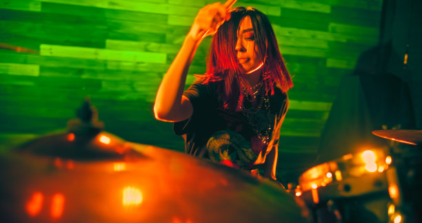 美丽的女孩与红发的肖像在舞台上鼓在摇滚表演图片下载