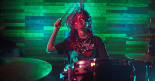 美丽女孩的肖像完美地打鼓在舞台上的摇滚音乐会图片下载