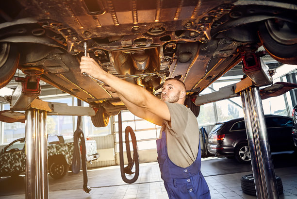 汽车机械师在维修站对汽车运行机构进行检查。男工人修理汽车。车辆维修的概念图片下载