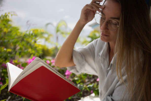 年轻女性阅读笔记本和做笔记。图片下载