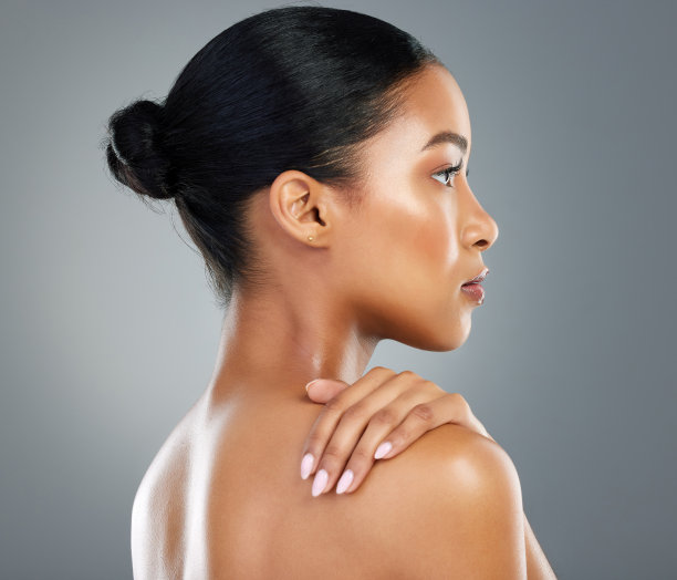 一个美丽的年轻女子在灰色的背景下摆姿势图片下载