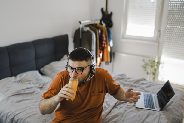 学生在线教学，在卧室喝橙汁图片下载