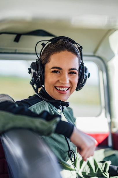 快乐的女机长的肖像，在飞机座位上手牵着手。图片下载