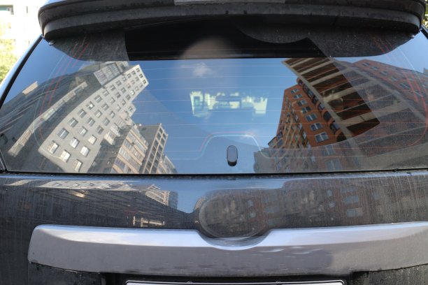 一辆汽车后窗映出的城市房屋的倒影图片下载