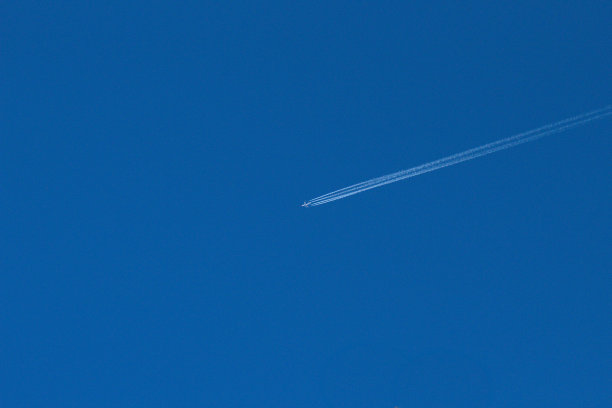 有尾迹的飞机在空中飞行图片下载