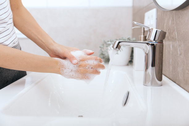 在水龙头下洗手。手部卫生概念细节。用肥皂洗手以预防冠状病毒的传播，防止冠状病毒在公共卫生间或公共卫生间的卫生传播图片下载