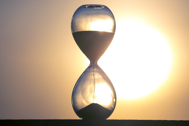 落日背景下的沙漏。时间在人生中的价值。一个永恒。图片下载