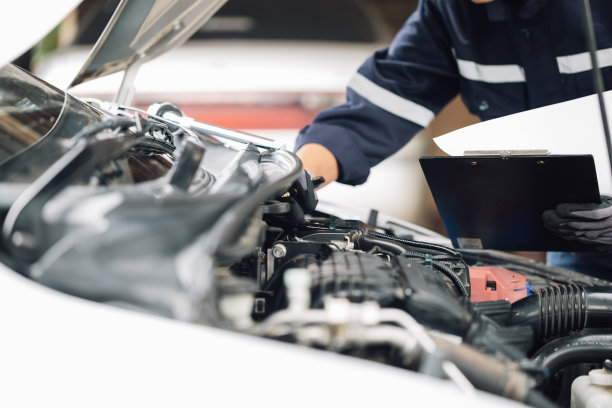 机械师在车库里修理汽车的发动机。维修服务。汽车检验服务和汽车维修服务的概念。图片下载