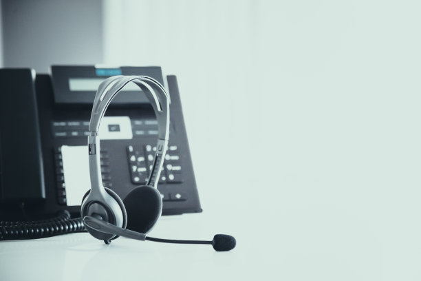 通信支持，呼叫中心和客户服务帮助台。电话键盘上的VOIP耳机。图片下载