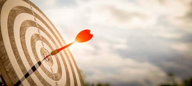 近距离射击红色飞镖箭在镖靶中心在深蓝色的天空背景。事业目标或成功目标与赢者观念。图片下载