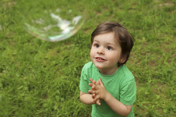 一个小男孩在玩肥皂泡。图片下载