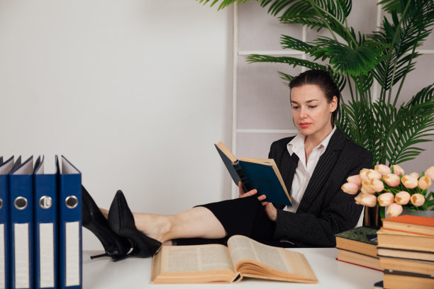 漂亮的女人坐在商务桌上在办公室里工作图片下载