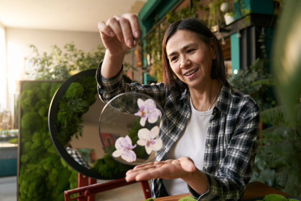女士拿着优雅的圆玻璃和鲜花图片下载