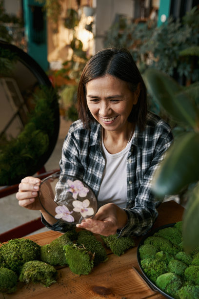微笑的女人拿着优雅的圆玻璃和花图片下载