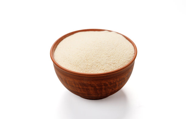 在白色的背景下，碗和袋子里的粗面粉被孤立起来。高质量的照片图片下载