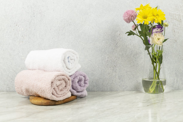 大理石地板上的花旁边有毛巾图片下载