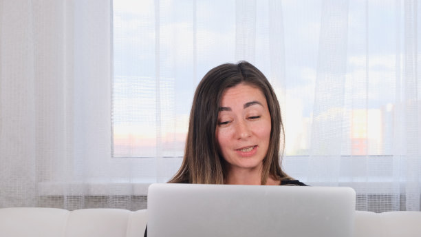 黑发女孩博主与朋友在社交网络上谈论笔记本电脑使用无线互联网。积极的年轻女性在网上购物图片下载