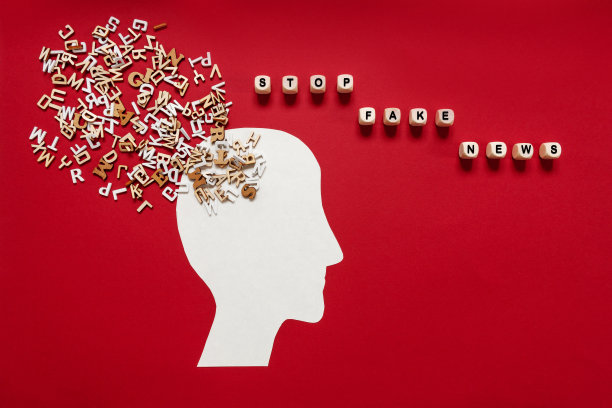 停止假新闻的概念。人的头部轮廓，许多不同的木制字母和短信图片下载