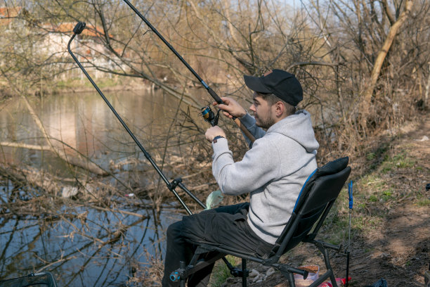 一个人坐着钓鱼的照片。在一个美丽的春日里展示钓鱼图片下载