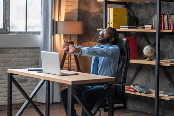 在工作场所做手腕伸展运动的男性员工图片下载