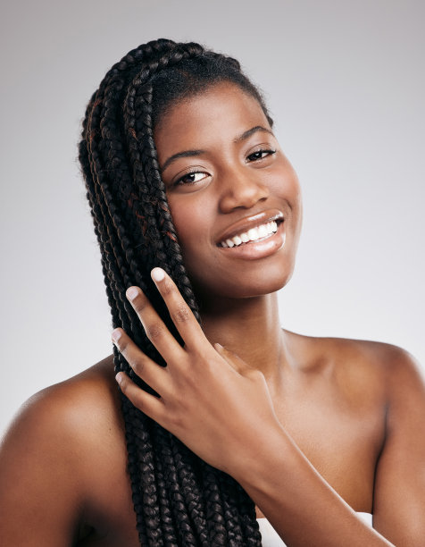 裁剪的肖像，一个有吸引力的年轻女子摆姿势在工作室的棕色背景图片下载