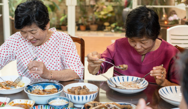 快乐老人双生老人社会生活理念。亚洲老年妇女在临终关怀社区的餐桌上共进晚餐。图片下载