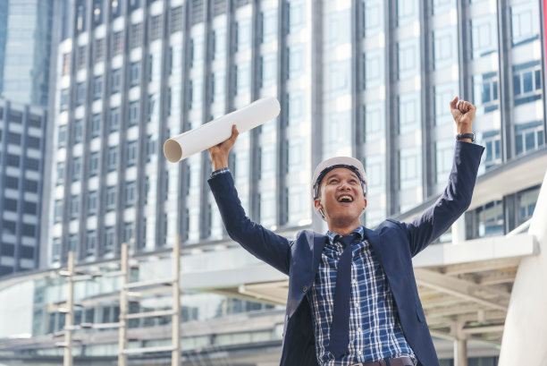 领导，商人积极的动机工程。胜利商人工程师力量握着拳头碰撞蓝图赢家正能量。在成功的城市生活中，背后的建筑赋予人力量图片下载