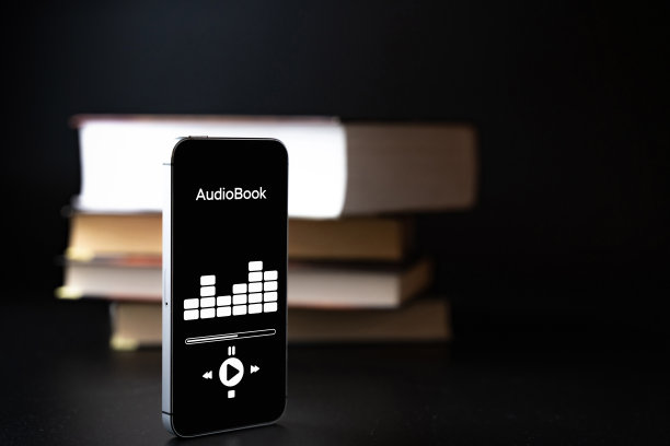有声读物的教育。智能手机屏幕与有声书应用程序上的纸书黑色背景。电子书学习电子互联网移动概念。图片下载